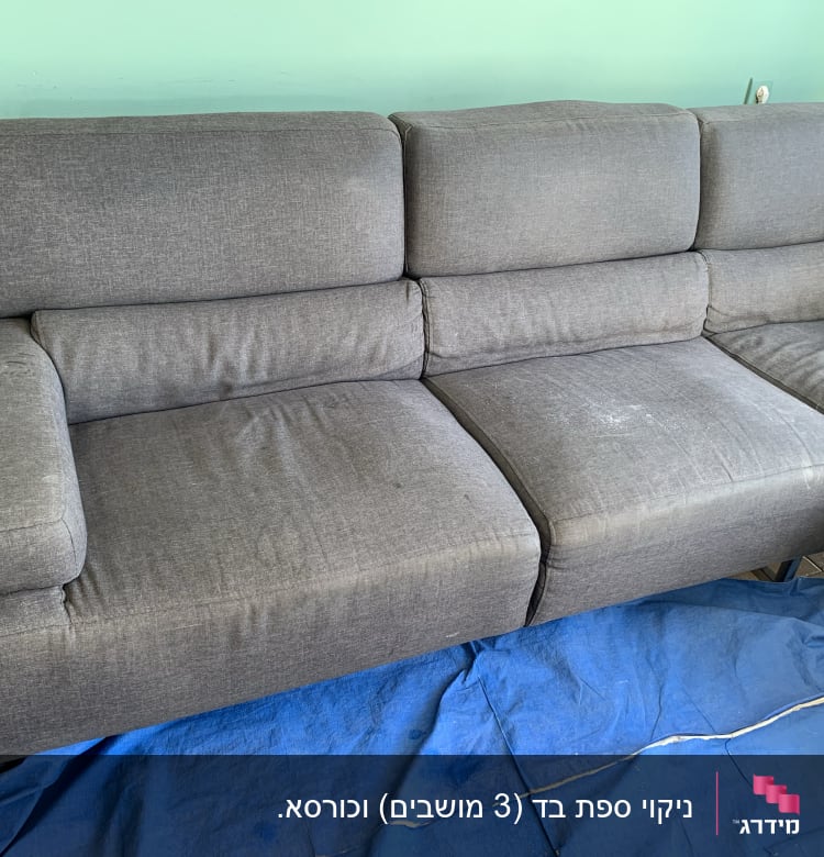 ספה אפורה עם כתמים על כיסוי כחול